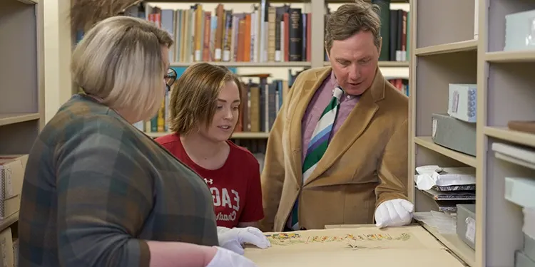 A history professor showing students items in an archive